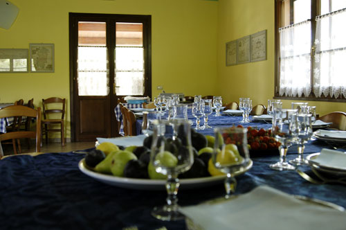 Sala da pranzo in cui i pasti vengono serviti in un unico tavolo.