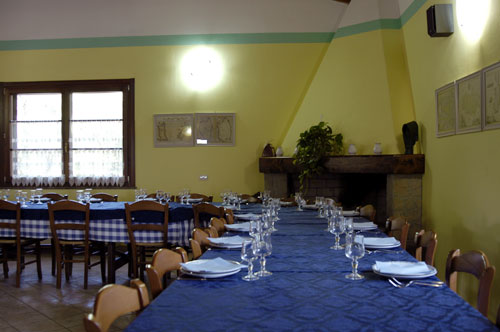 Sala da pranzo in cui i pasti vengono serviti in un unico tavolo.