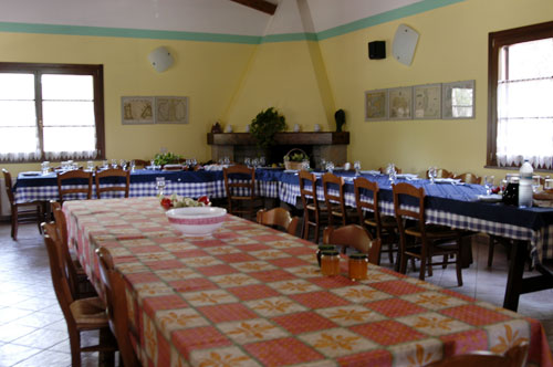 Sala da pranzo in cui i pasti vengono serviti in un unico tavolo.