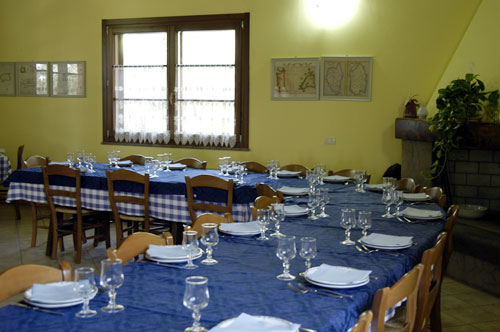 Sala da pranzo in cui i pasti vengono serviti in un unico tavolo.
