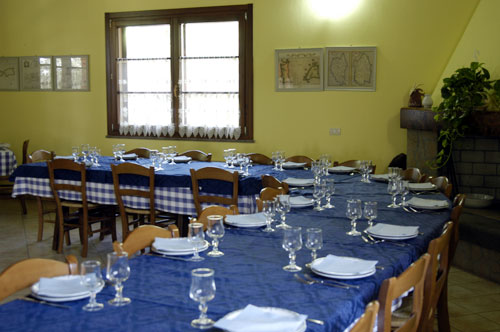 Sala da pranzo in cui i pasti vengono serviti in un unico tavolo.